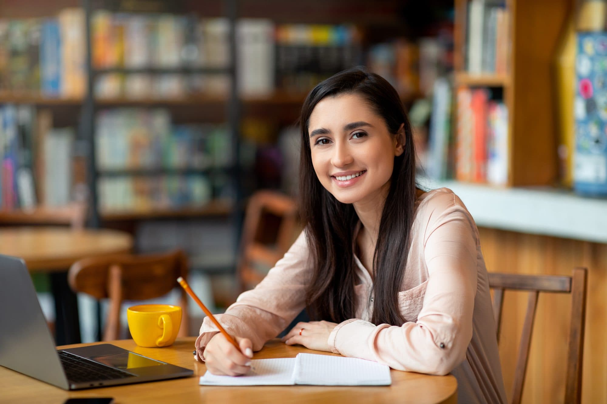 Alumna de la prepa UNIJAL sonriendo con su laptop